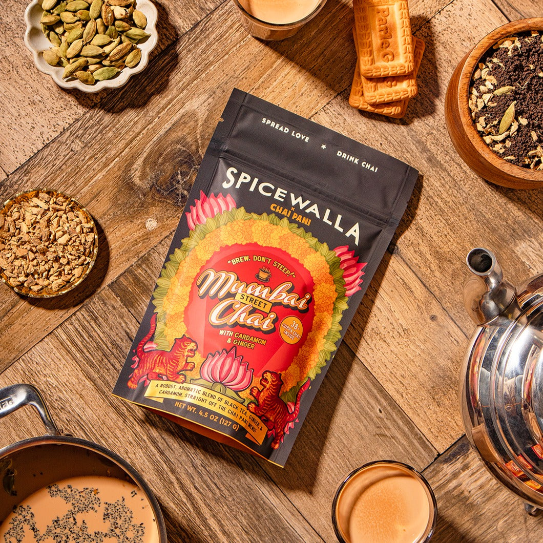 Spicewalla Mumbai Chai tea package on a wooden surface with tea-making items.