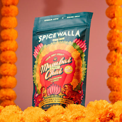 Spicewalla Mumbai Sweet Chai package with marigold flowers on a pink background