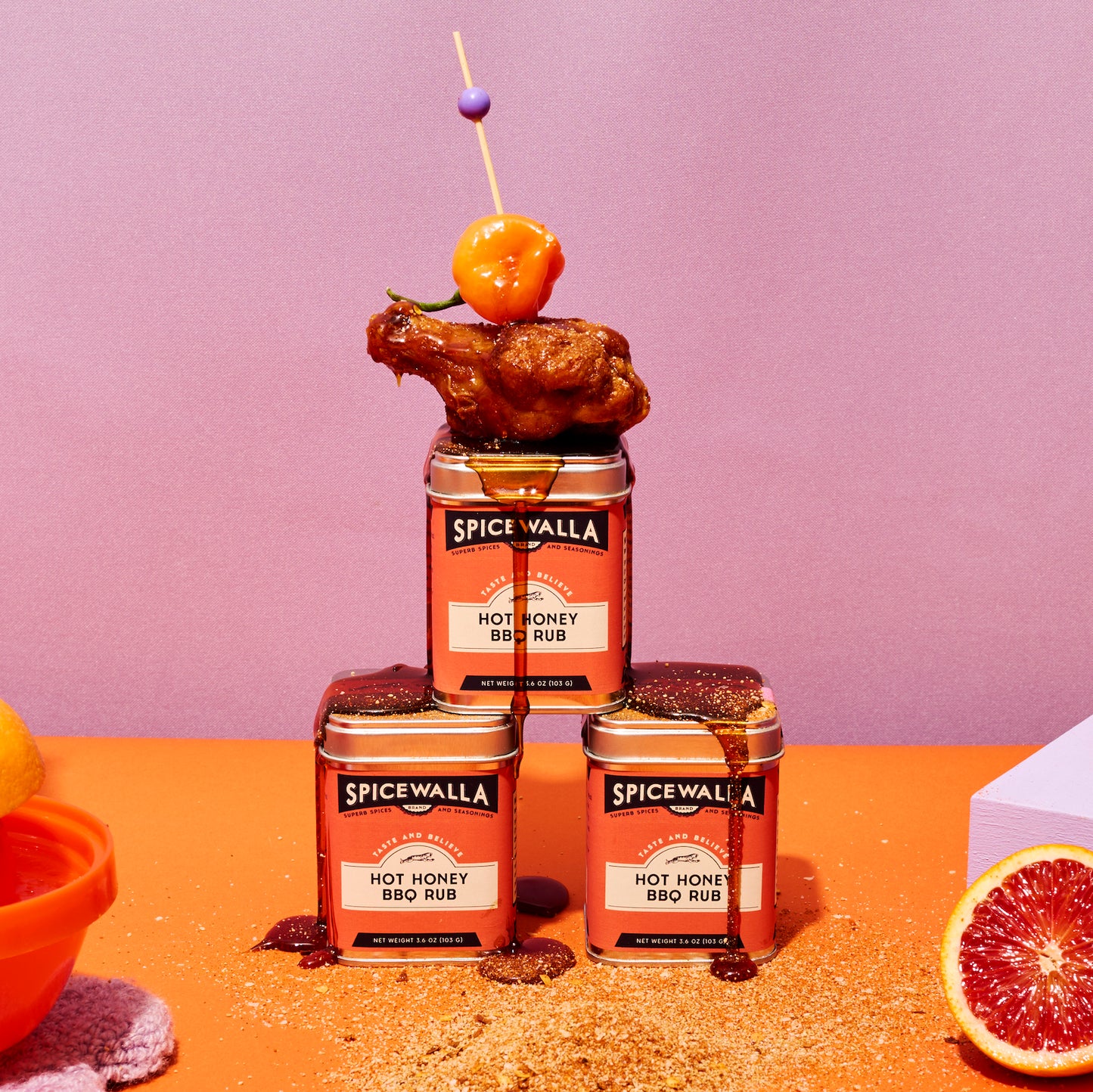 Spicewalla Hot Honey BBQ Rub tins displayed with fried chicken purple background