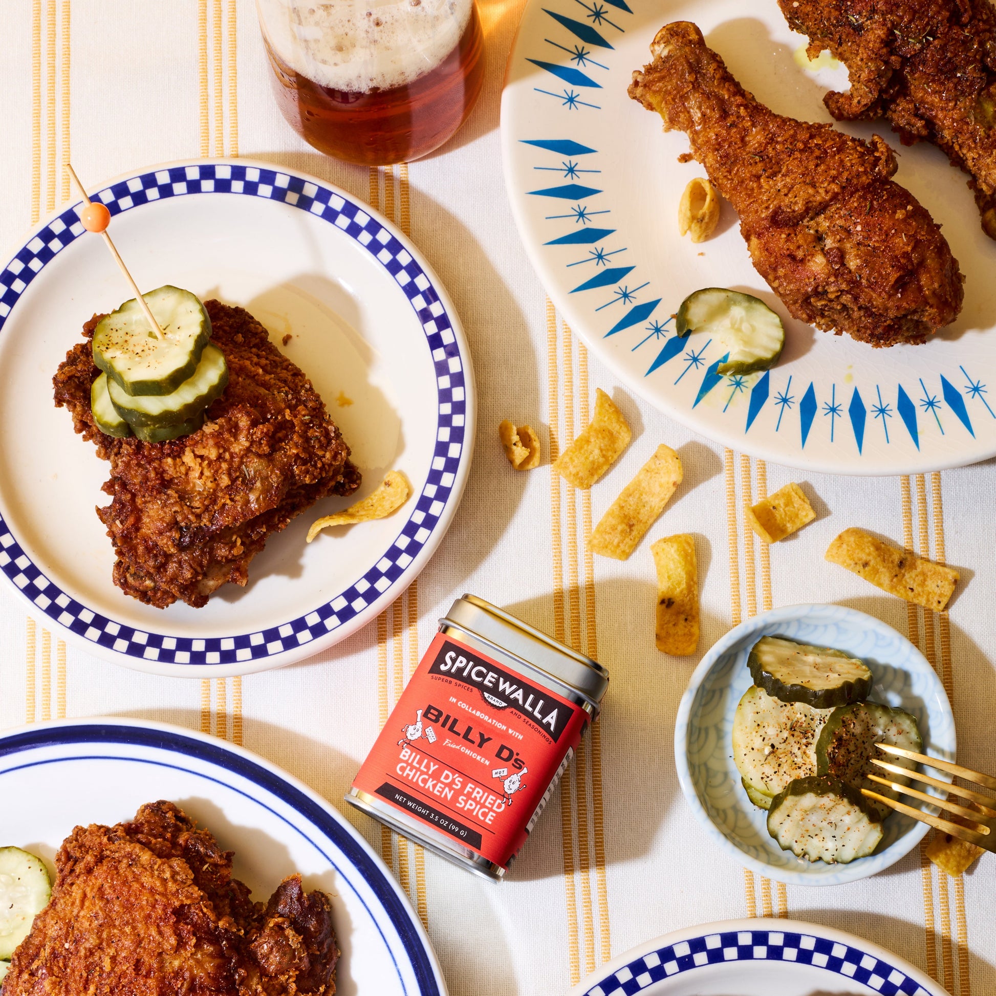 Spicewalla Billy D's Chicken Blend laying on table surrounded by plates of friend chicken