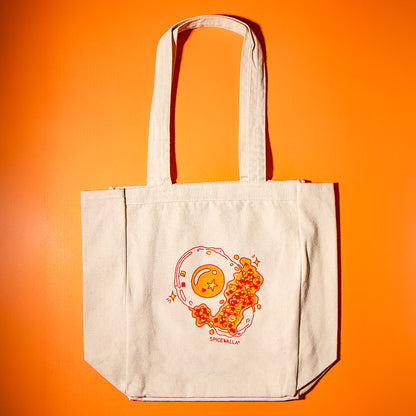 Beige tote bag with orange graphic design on an orange background