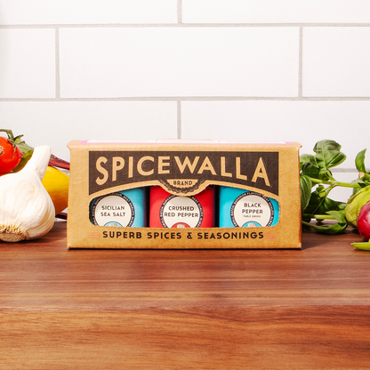 Spicewalla spice set on a wooden surface with vegetables in the background