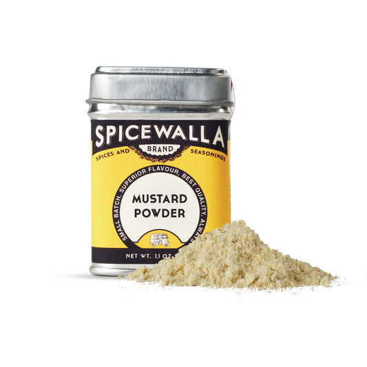 Spicewalla mustard powder jar with mustard powder spilling out on a white background