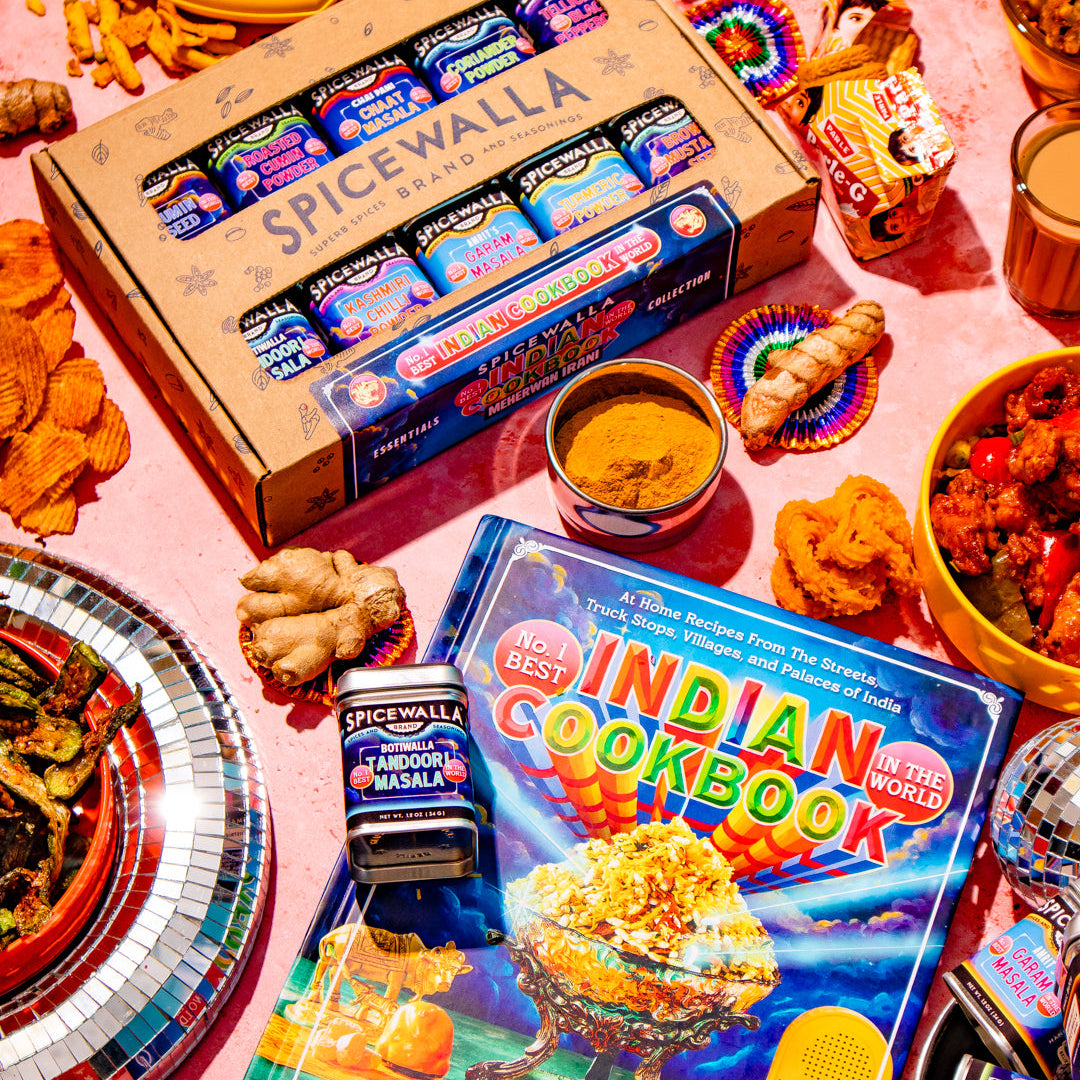 A styled flat-lay featuring a box of Spicewalla spices with Meherwan Irani's No. 1 Best Indian Cookbook in the World
