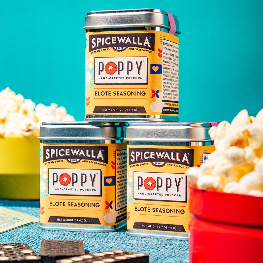 Spicewalla Poppy Elote Seasoning tins with popcorn on a blue background