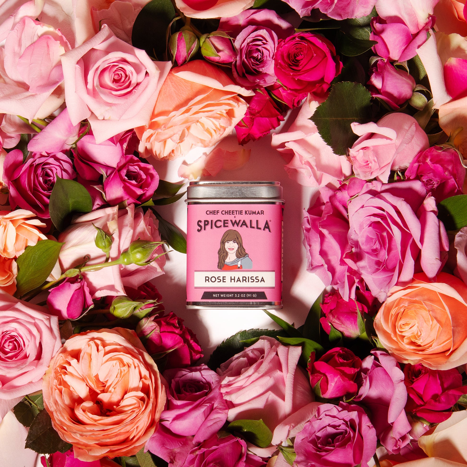 Spicewalla Rose Harissa can surrounded by pink and orange roses