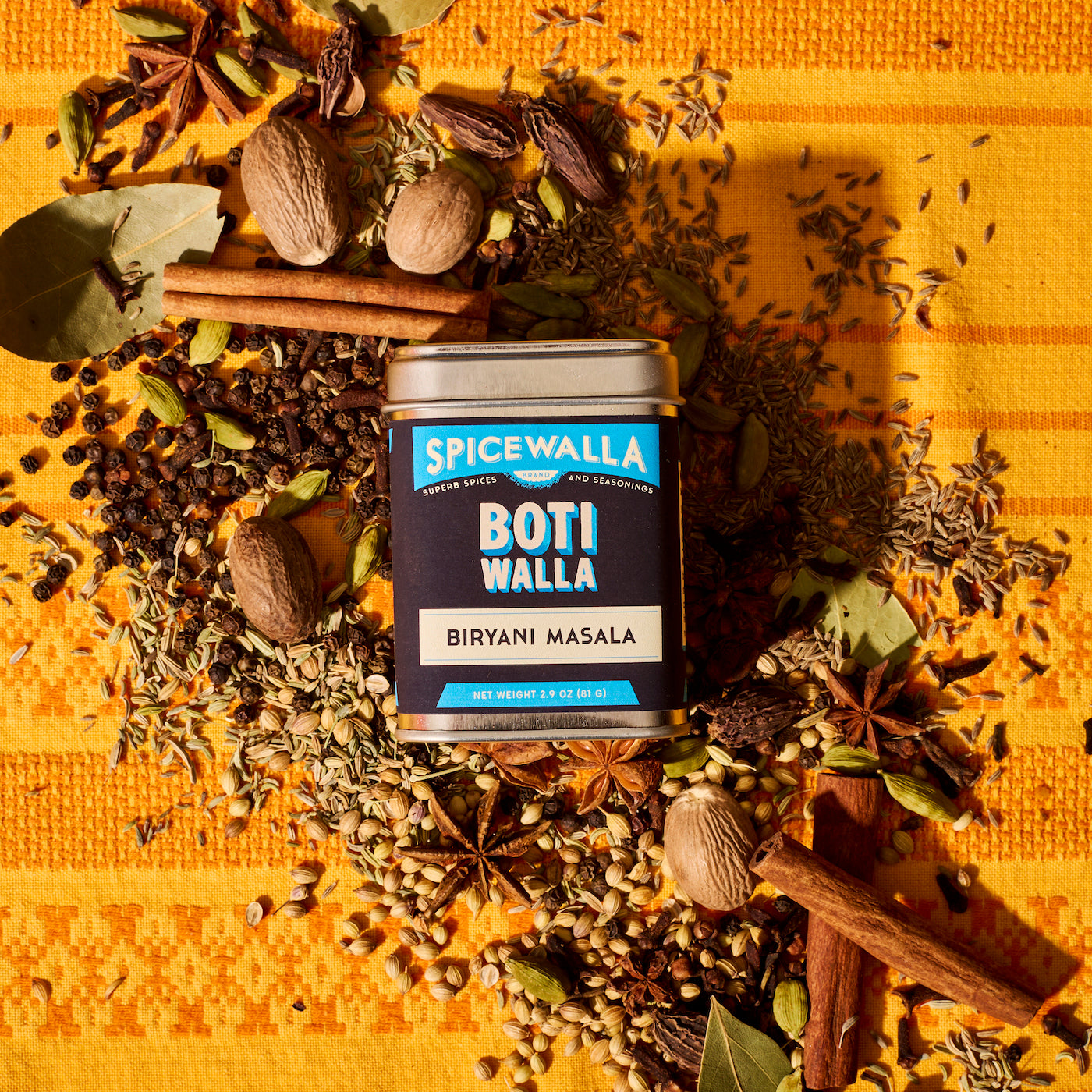 Spicewalla Botiwalla Biryani Masala tin with ingredients on an orange tablecloth 