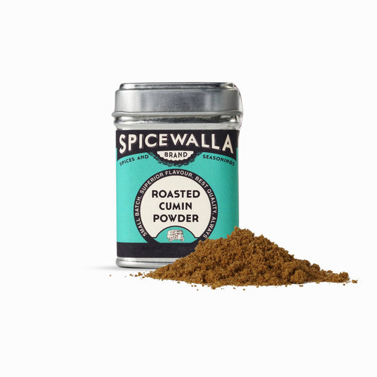 Spicewalla roasted cumin powder container with cumin powder spilling out on a white background