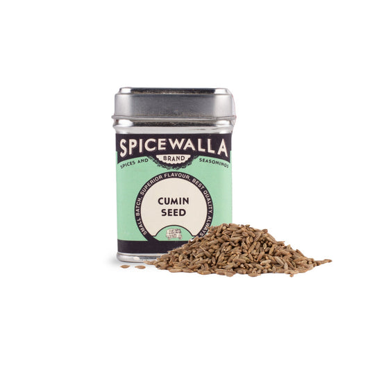 Spicewalla cumin seed canister with cumin seeds spilling out on a white background